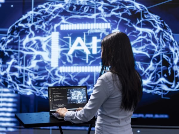 Programmer analyzing complex AI brain models on laptop, running simulations. Female employee using machine learning software on notebook device to develop artificial intelligence technology